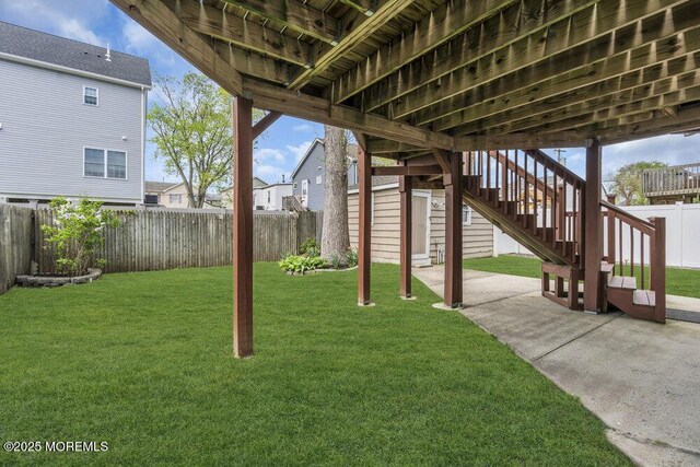 view of yard featuring a patio, a fenced backyard, and stairway