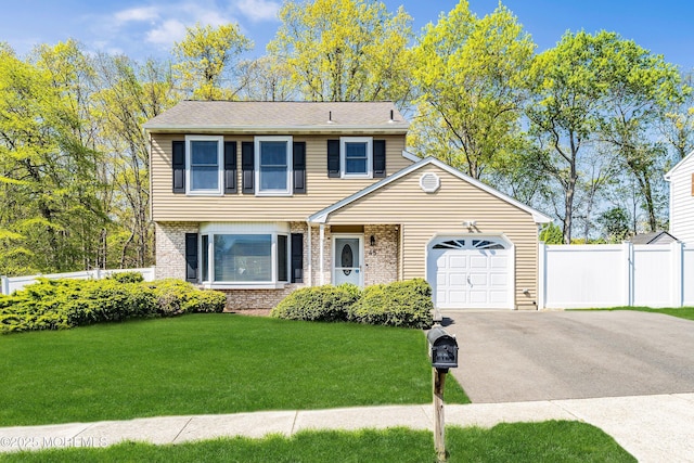 view of front of house featuring an attached garage, fence, aphalt driveway, a front lawn, and brick siding