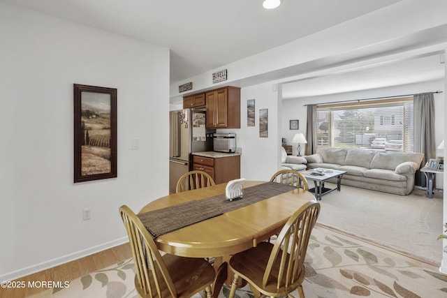 dining room with light wood-style flooring and baseboards