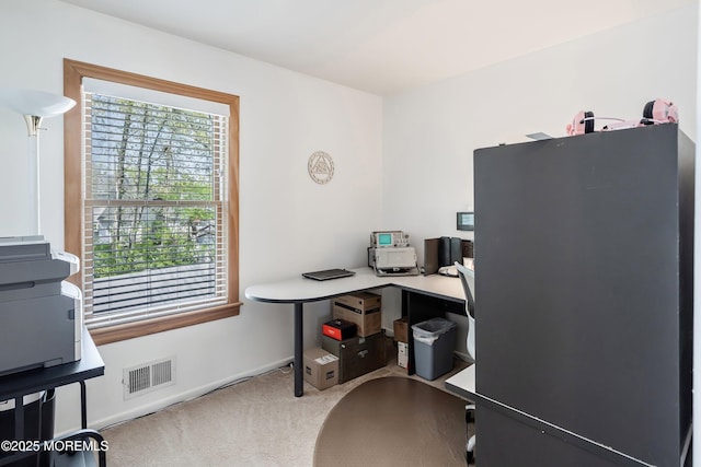carpeted office with baseboards and visible vents