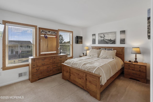 bedroom with baseboards, light carpet, and visible vents