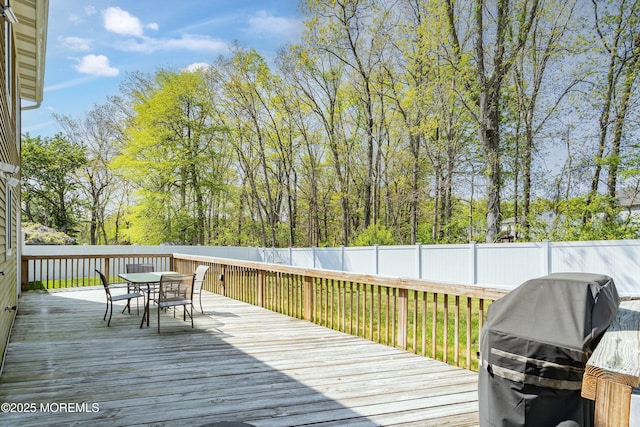 deck featuring a fenced backyard, a grill, and outdoor dining space