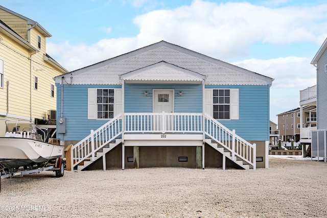 rear view of property featuring stairs and a porch