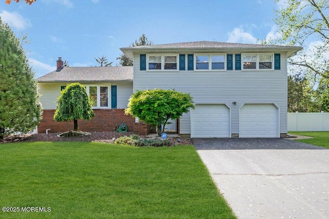 split level home with an attached garage, driveway, and a front yard