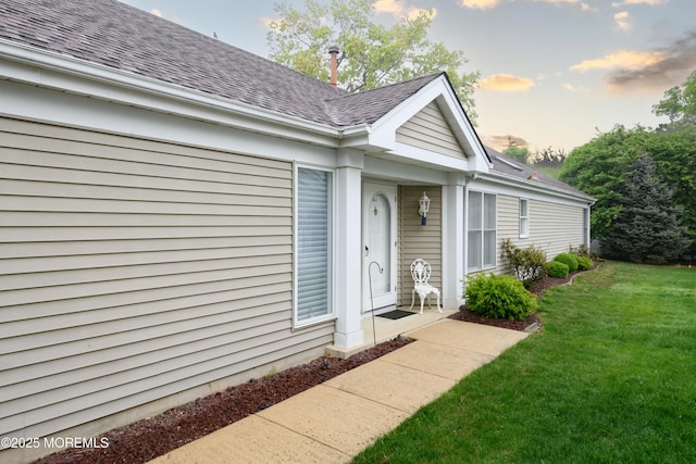 2271 Kira Ct, Toms River, NJ 08755 - exterior entry at dusk with a lawn and a shingled roof