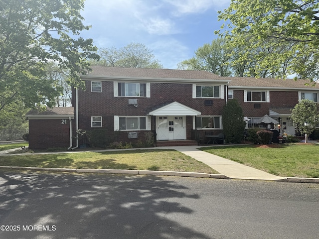 view of front of house with brick siding and a front lawn