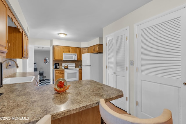 14 Dolan Ave, Aberdeen, NJ 07747 - kitchen with a sink, a peninsula, white appliances, and light countertops