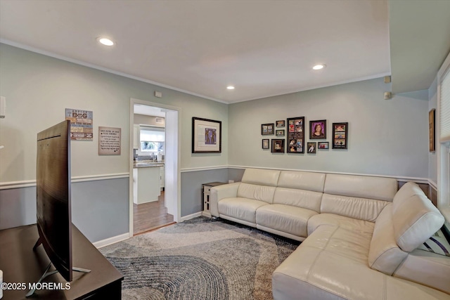 living area featuring crown molding, baseboards, and recessed lighting