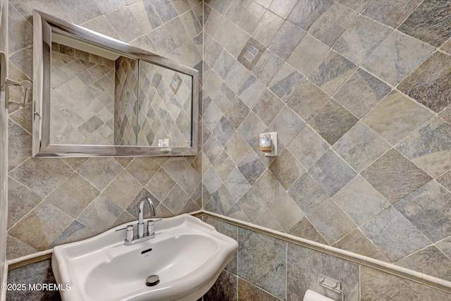 bathroom with tile walls and a sink