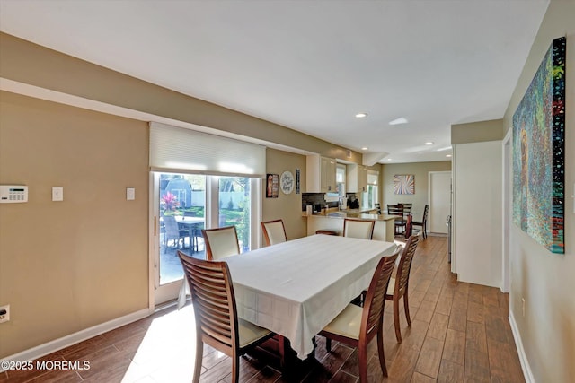 dining space with baseboards, recessed lighting, and light wood-style flooring