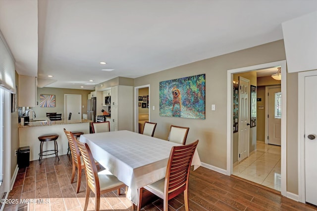 dining room featuring recessed lighting, baseboards, visible vents, and wood tiled floor