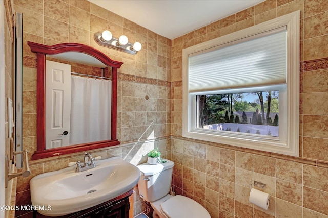 full bathroom with vanity, toilet, and tile walls