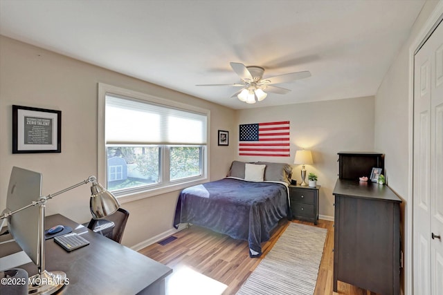 bedroom featuring a ceiling fan, baseboards, visible vents, and light wood finished floors