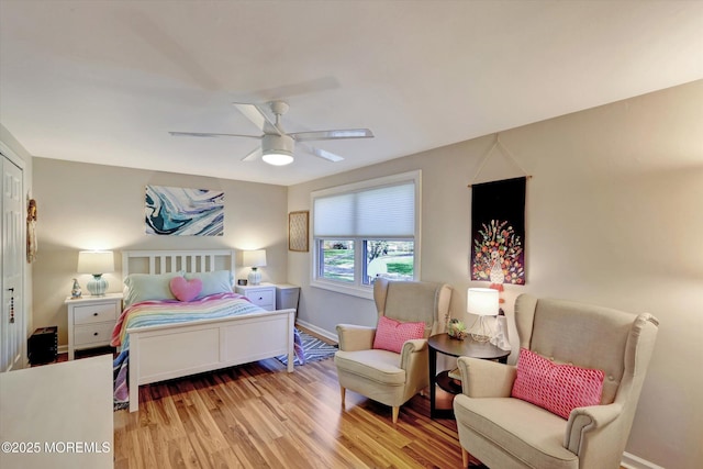 bedroom featuring baseboards, a ceiling fan, and light wood finished floors