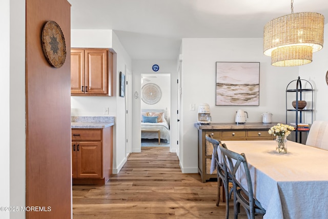 interior space featuring an inviting chandelier, baseboards, and light wood-type flooring