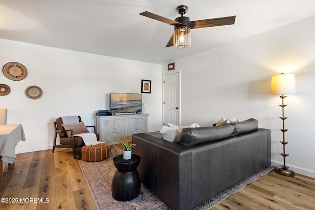 living room with baseboards, ceiling fan, and wood finished floors