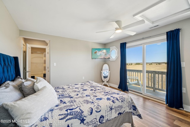 bedroom with a ceiling fan, attic access, visible vents, wood finished floors, and access to outside