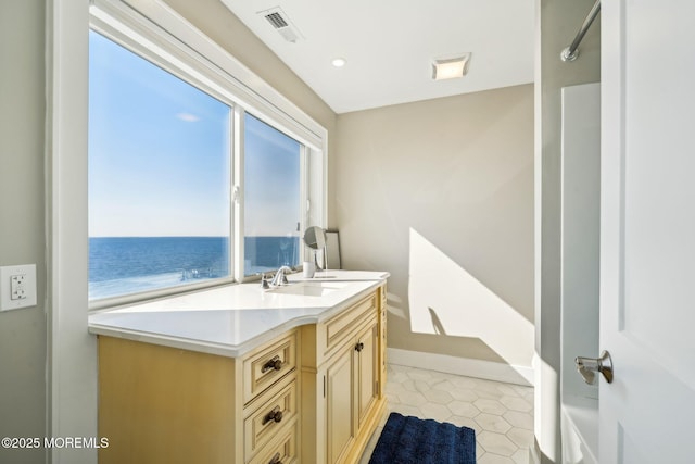 bathroom featuring visible vents, tile patterned floors, baseboards, vanity, and a water view