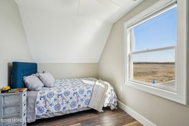 bedroom featuring baseboards, dark wood finished floors, and lofted ceiling