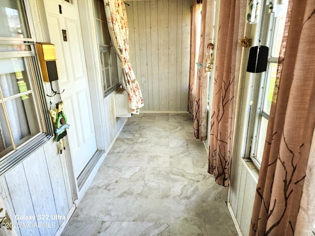 hallway with wood walls and a healthy amount of sunlight