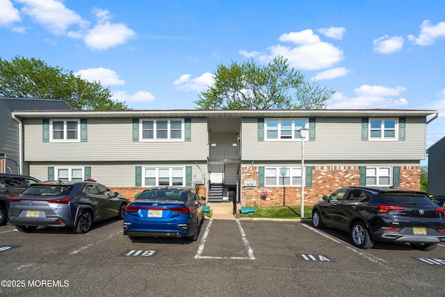 multi unit property featuring brick siding and uncovered parking