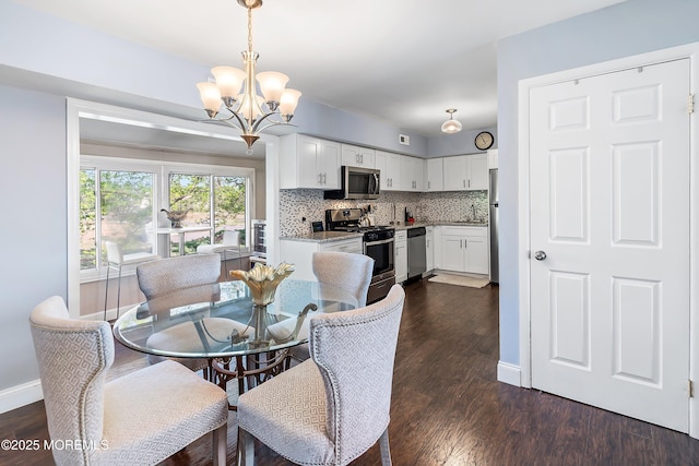 dining space with baseboards, an inviting chandelier, and dark wood-style floors