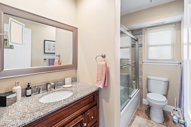 bathroom featuring vanity, baseboards, bath / shower combo with glass door, tile patterned floors, and toilet