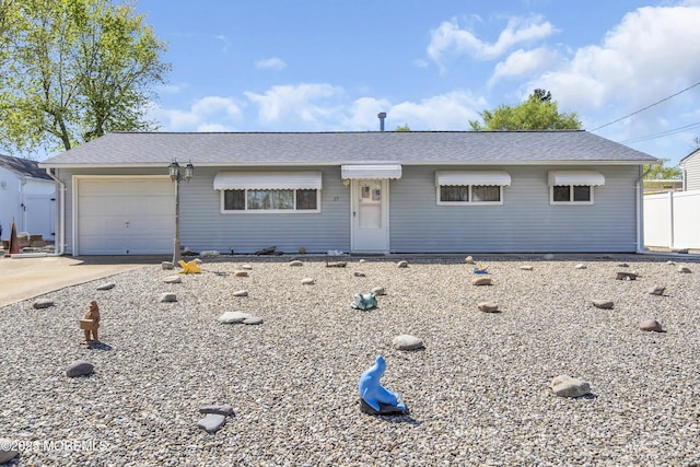 single story home with a shingled roof, an attached garage, and driveway