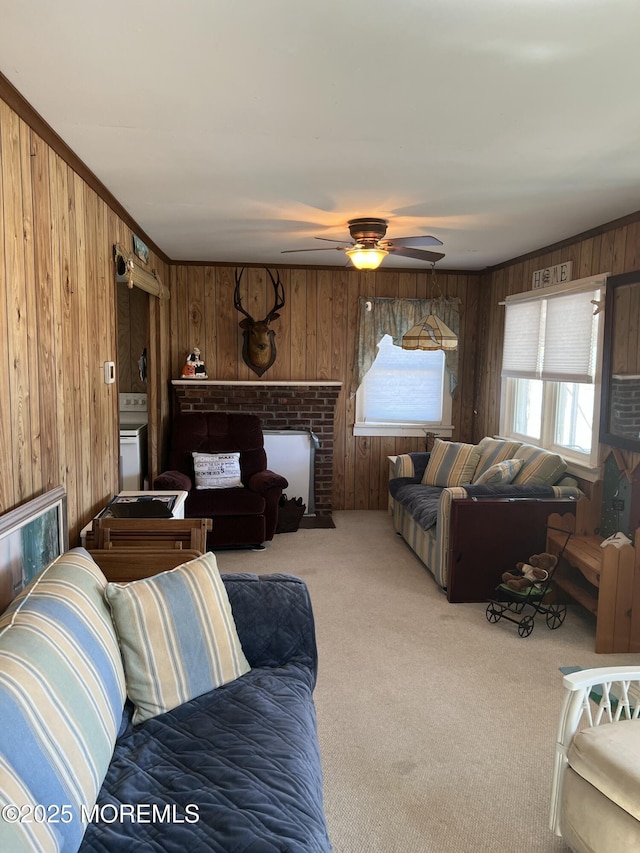 carpeted living area featuring wooden walls, ceiling fan, and a brick fireplace