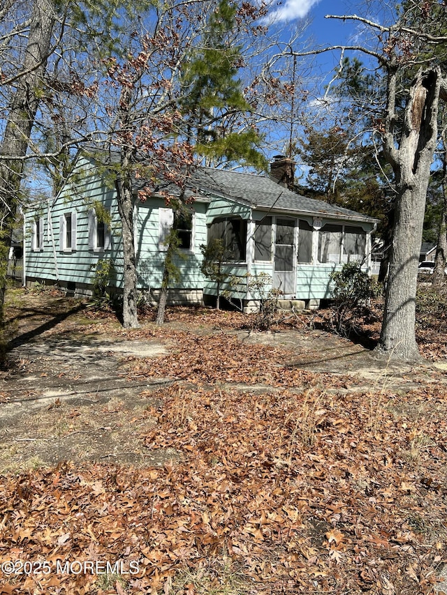 view of front of property with a chimney and a sunroom