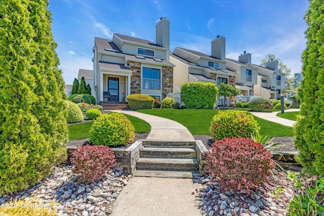 view of front of house featuring a residential view, a front lawn, and stone siding