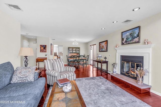 living room featuring a chandelier, visible vents, wood finished floors, and recessed lighting
