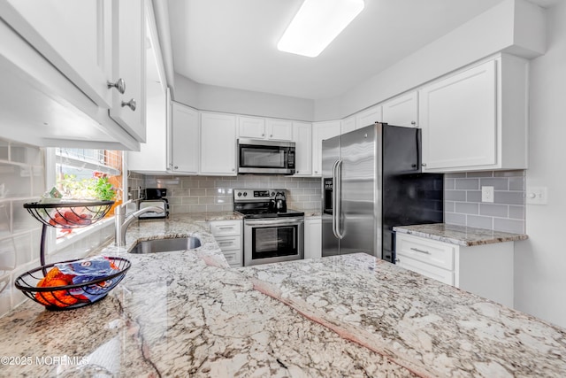 kitchen featuring a sink, white cabinetry, appliances with stainless steel finishes, and tasteful backsplash