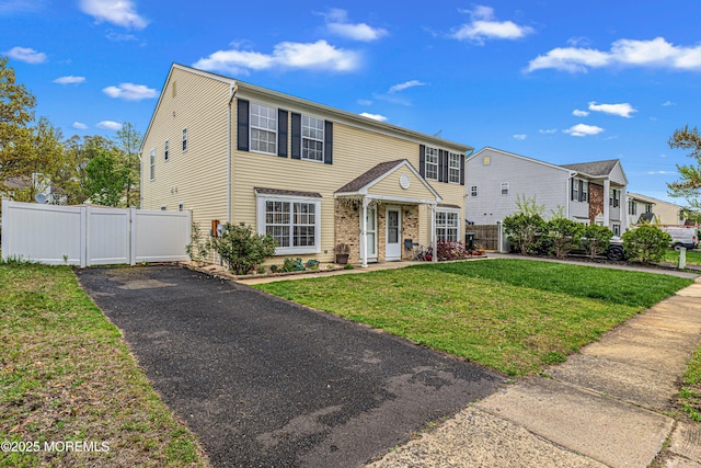 view of front of house with fence, a gate, driveway, and a front yard
