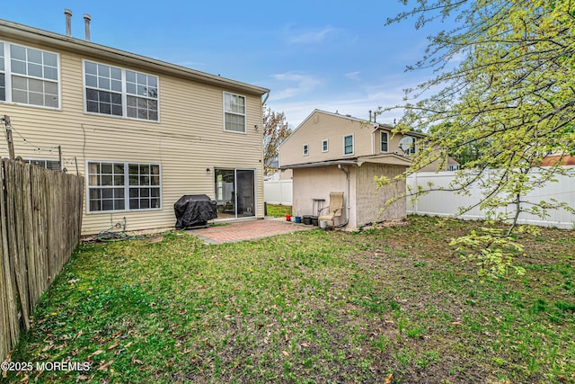 back of property with a lawn, a fenced backyard, and a patio area