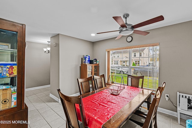 dining area featuring baseboards, ceiling fan with notable chandelier, and light tile patterned floors