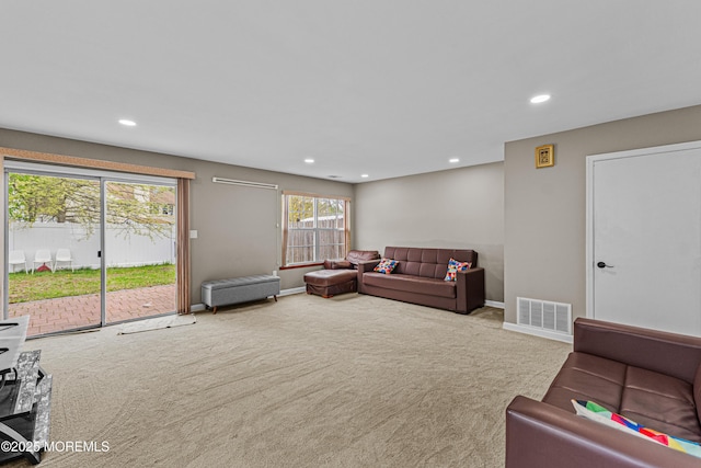 carpeted living area with visible vents, recessed lighting, and baseboards