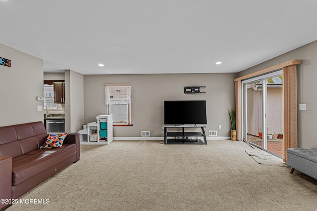 living area featuring a wealth of natural light, recessed lighting, and light colored carpet