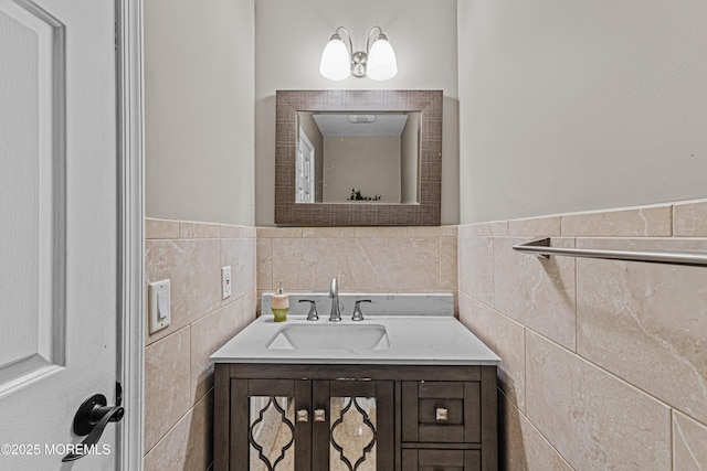 bathroom featuring vanity, a wainscoted wall, and tile walls