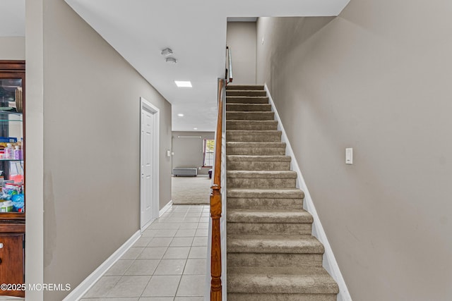 staircase featuring baseboards, tile patterned flooring, and recessed lighting