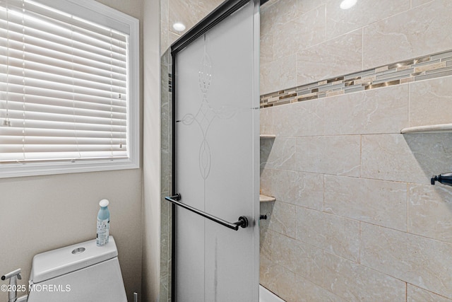 full bathroom featuring toilet and a shower stall