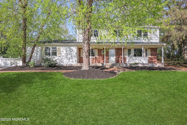 2338 Ramshorn Dr, Allenwood, NJ 08720 - view of front facade featuring fence, covered porch, a front lawn, and brick siding