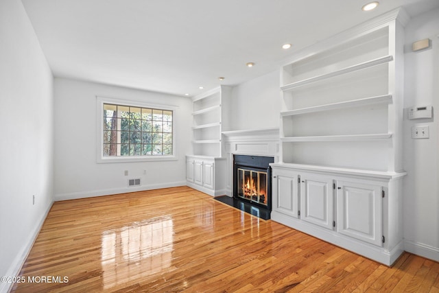 2338 Ramshorn Dr, Allenwood, NJ 08720 - unfurnished living room featuring baseboards, visible vents, a fireplace with flush hearth, and wood finished floors