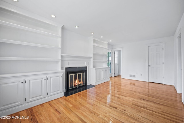 2338 Ramshorn Dr, Allenwood, NJ 08720 - unfurnished living room featuring visible vents, a fireplace with flush hearth, light wood-style floors, and recessed lighting