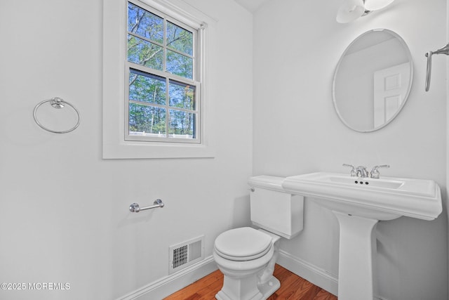 2338 Ramshorn Dr, Allenwood, NJ 08720 - half bathroom with visible vents, wood finished floors, toilet, baseboards, and a sink