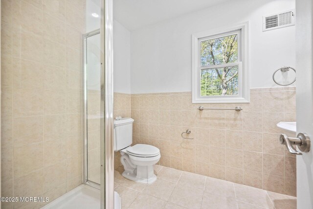 2338 Ramshorn Dr, Allenwood, NJ 08720 - bathroom featuring tile walls, toilet, visible vents, and a stall shower