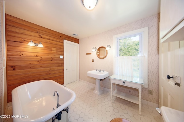 bathroom with a freestanding tub and wallpapered walls
