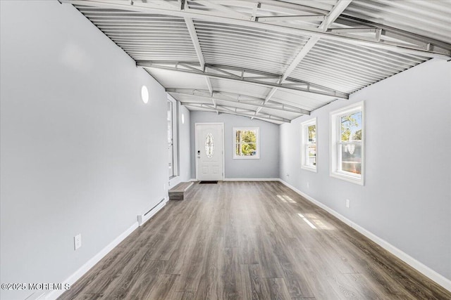 interior space with vaulted ceiling with beams, baseboards, wood finished floors, and a baseboard radiator