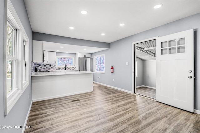 interior space with baseboards, recessed lighting, light wood-style flooring, and visible vents