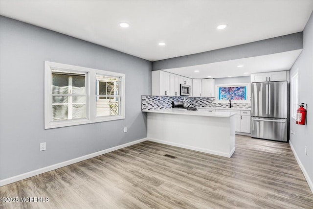 kitchen with visible vents, plenty of natural light, appliances with stainless steel finishes, and light wood-style floors